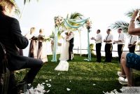 Garden-style chuppah, draping fabric, on the grass by the ocean