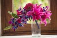 Tropical wedding bouquet with pink gerberas, lilies and a touch of purple