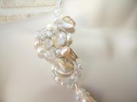 Mother of pearl natural shells, pale pink pearls and clear crystals have been united to form a tri-strand necklace with a handcrafted wire wrapped pendant that lies beautifully on the collar bone. Sparkle with this necklace for your walk down the aisle!
