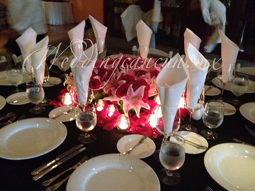 oriental lilies and fucsia roses centerpiece with candle votives
