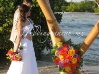 colorful wedding bouquet with orange roses and yellow roses, purple lisianthus and foliage