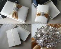 Ivory silk box for wedding invitation with crystal brooch.