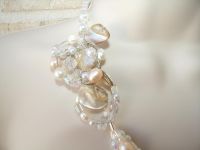 Mother of pearl natural shells, pale pink pearls and clear crystals have been united to form a tri-strand necklace with a handcrafted wire wrapped pendant that lies beautifully on the collar bone. Sparkle with this necklace for your walk down the aisle!
