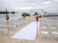 bamboo gazebo with white drapings and colorful floral aisle decor